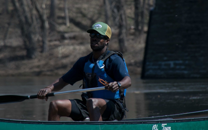 a person paddles a canoe on an outward bound veterans expedition